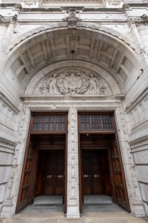 London, United Kingdom - 15 May 2025: Massive carved wooden doors beneath the highly ornate arch of