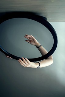 Portrait of a woman behind a mirror, hand in front of the mirror, interior view