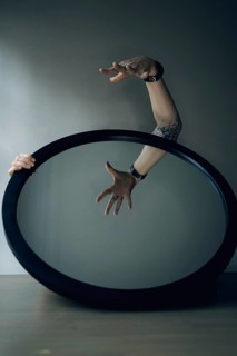 Portrait of a woman behind a mirror, interior view, hand in front of the mirror