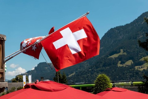 A flag of Switzerland pictured in Champery, a village by the French border with mountains at the
