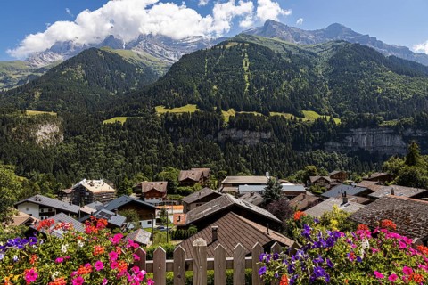 Postcard view of some mountains in Champery with flowers and chalets, in Switzerland