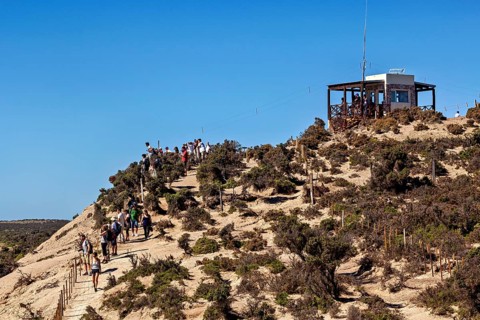 Hiker on a hill trail with views and an observation point in the blue sky, The countryside of
