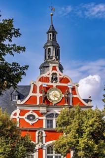 Magnificent baroque building with clock and decorative bell tower against a blue sky, the old town