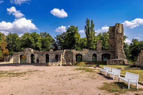 Ruins with stone walls, benches and trees under a clear sky, The Niedeck Ruins in Arnstadt