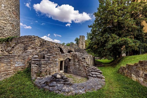 Ruins made of stone with a tree on a green field under a clear sky, The Niedeck Ruins in Arnstadt