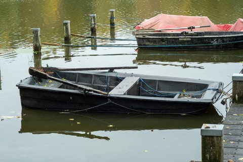 Borken-Hoxfeld, NRW, Germany, A weathered black boat is moored at the dock, surrounded by tranquil