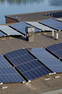 Solar panels on roof of apartment building, renewable green sustainable energy concept, water