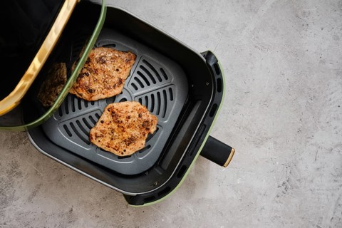 Juicy pork loin cutlets are seasoned and placed inside an air fryer for a healthy cooking method.