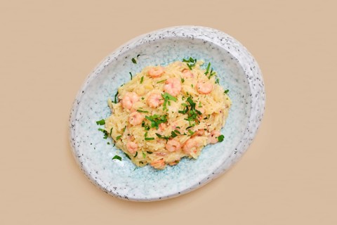 A delightful dish features risoni pasta mixed with tender shrimp and sprinkled with fresh herbs.