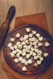 Traditional Turkish dumplings, raw, on a cutting board, top view, no people