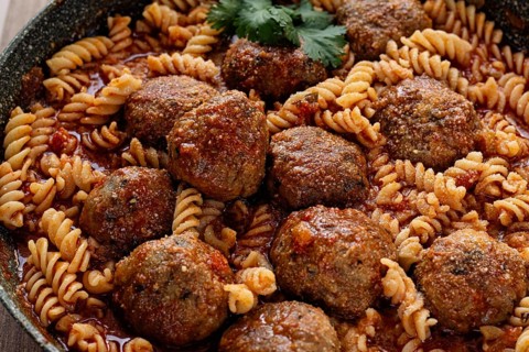 Minced meat meatballs, in tomato sauce, with fusilli pasta, in a cast-iron pan, homemade, no people