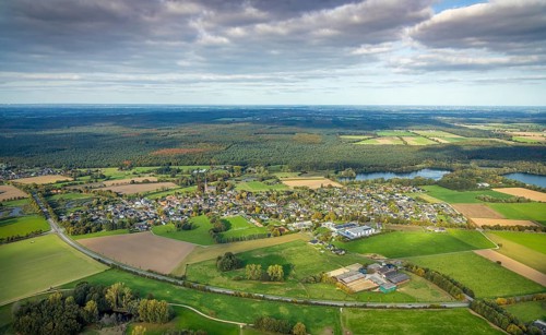 Aerial view, residential area district of Kessel with St. Stephen's Church and Reichswald, blue sky