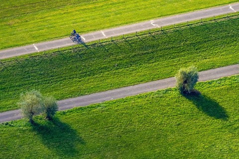 Aerial view, cycle path and cyclist in the foothills of the Rhine Perrich, green meadows and green