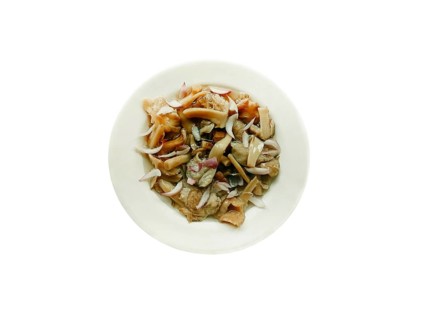 Delicious dish in the form of homemade salted mushrooms with onions in a plate on a white