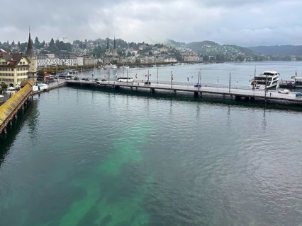 Harbour view with boats, buildings and hills in the background under cloudy sky, Lucerne,