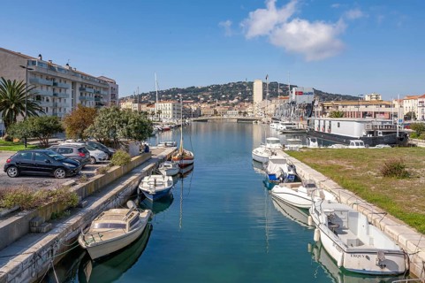 View from Pont des Dockers across the Canal de la Peyrade with moored boats along the quays towards