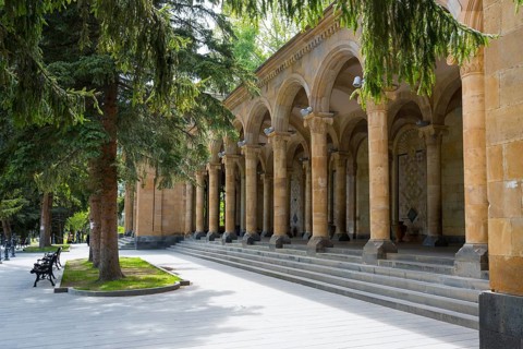 Arch making in a park with stone arches and tall trees in sunny weather, Mineral Water Gallery in