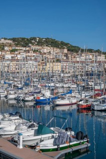 Densely packed sailboats and yachts with numerous masts in the port of Sete, with the densely built