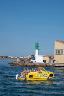 Sightseeing on the water: a yellow water car with tourists and lemon decorations rides on the Canal