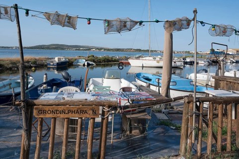 A fisherman's sitting area for an aperitif with tables and chairs as well as fishing nets as