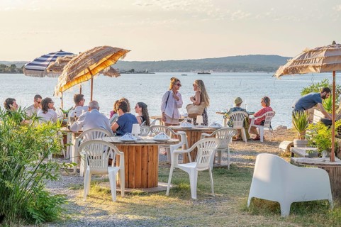 Summer scene on the terrace of the Guinguette A la bonne Franquette with guests sitting at tables