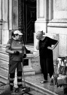 Black and white photography, street art, senior woman talking to a municipal cleaning employee,