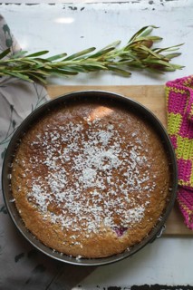 Coconut cake in an antique baking dish on a wooden board