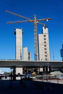 Yellow cranes on construction site of timber building Kaj 16 with hybrid concrete frames, sunny