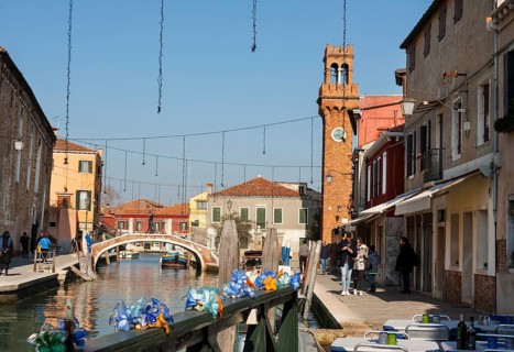 Clock tower and bridge on canal on island Murano, Venice, Italy