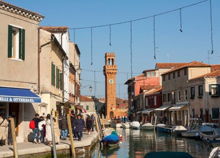 Clock tower and canal on island Murano, Venice, Italy