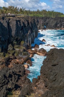Massive, black lava cliffs rise steeply out of the Indian Ocean at Cap Mechant, where white surf