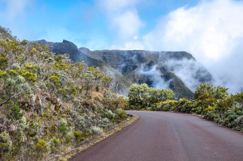 The curvy Route du Volcan snakes downhill through the contrasting landscape, with silvery-green and