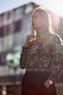 Elegant designer woman in sunlight in front of futuristic modern architecture house, apartment