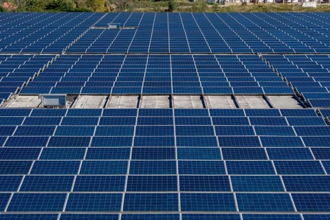 Extensive array of blue solar panels covering a rooftop, capturing sunlight and converting it into