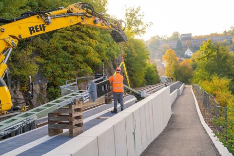 Track work with excavator, construction worker fixing objects, autumn urban landscape, signal