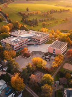 Maria von Linden Gymnasium school building in rural autumn surrounded by colorful trees, taken from