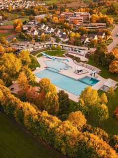 Aerial view of an outdoor pool in an autumn setting with colorful trees, Calw, Black Forest,