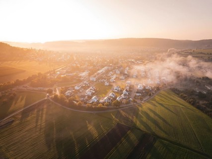 A small town surrounded by fields at sunrise with enchanting fog, Calw Stammheim, Black Forest,
