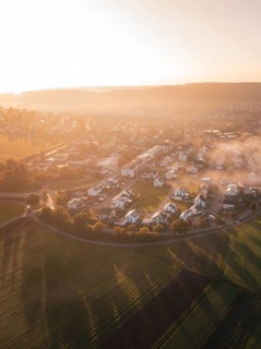 Village and fields in morning fog with warm shades of sunrise light, Calw Stammheim, Black Forest,