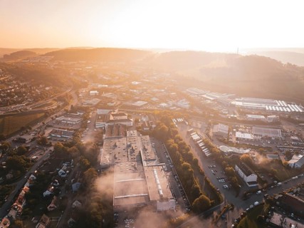 Aerial view of an industrial urban area and fields in orange morning fog, Calw Stammheim, Black