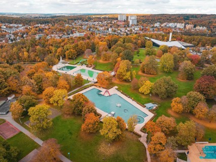 A swimming pool surrounded by autumn trees, nestled in a large park, Sindelfingen, Böblingen