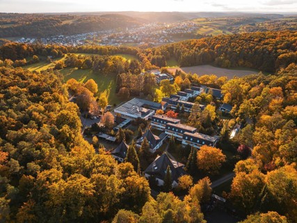 Motherhouse building in autumn landscape with sunset and village in background, Aidlingen,