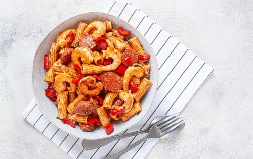 Jambalaya pasta with shrimp and sausages, cooked with bell pepper in a frying pan, homemade, on a