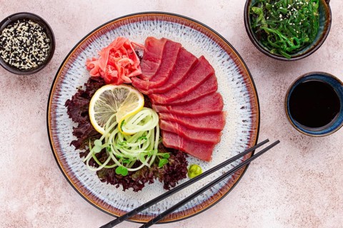 Freshly prepared sashimi with vibrant garnishes served on a decorative plate