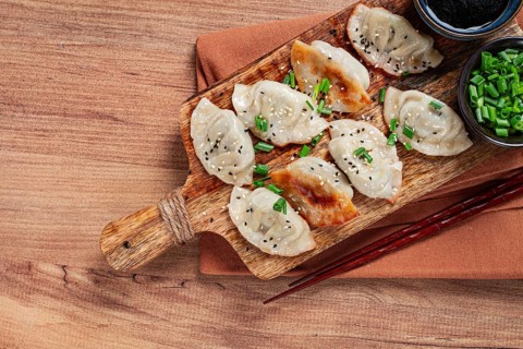 Gyoza Japanese dumplings, fried, with sauce, with green onion and sesame seeds, no people,