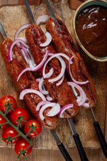 Fried sausages, in English with bacon, for grilling, on a cutting board, top view, no people