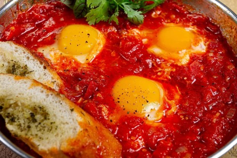 Shakshuka, breakfast, fried eggs in tomato sauce, with spices and herbs, homemade, no people