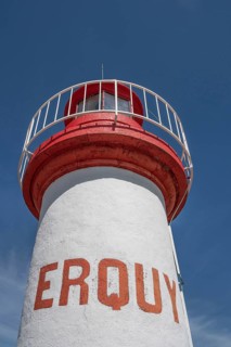 An extreme bottom view shows the upper, cylindrical part of the white-red lighthouse of Erquy,
