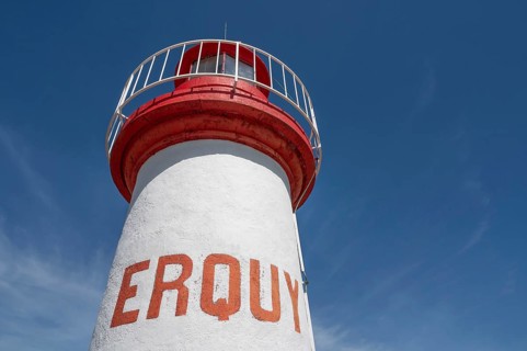 An extreme bottom view shows the upper, cylindrical part of the white-red lighthouse of Erquy,