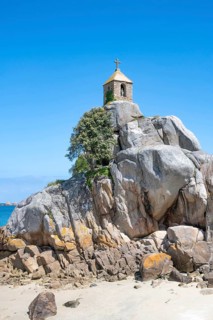 The small, historic Saint-Gildas chapel is perched on rugged, pink rock formations on the banks of